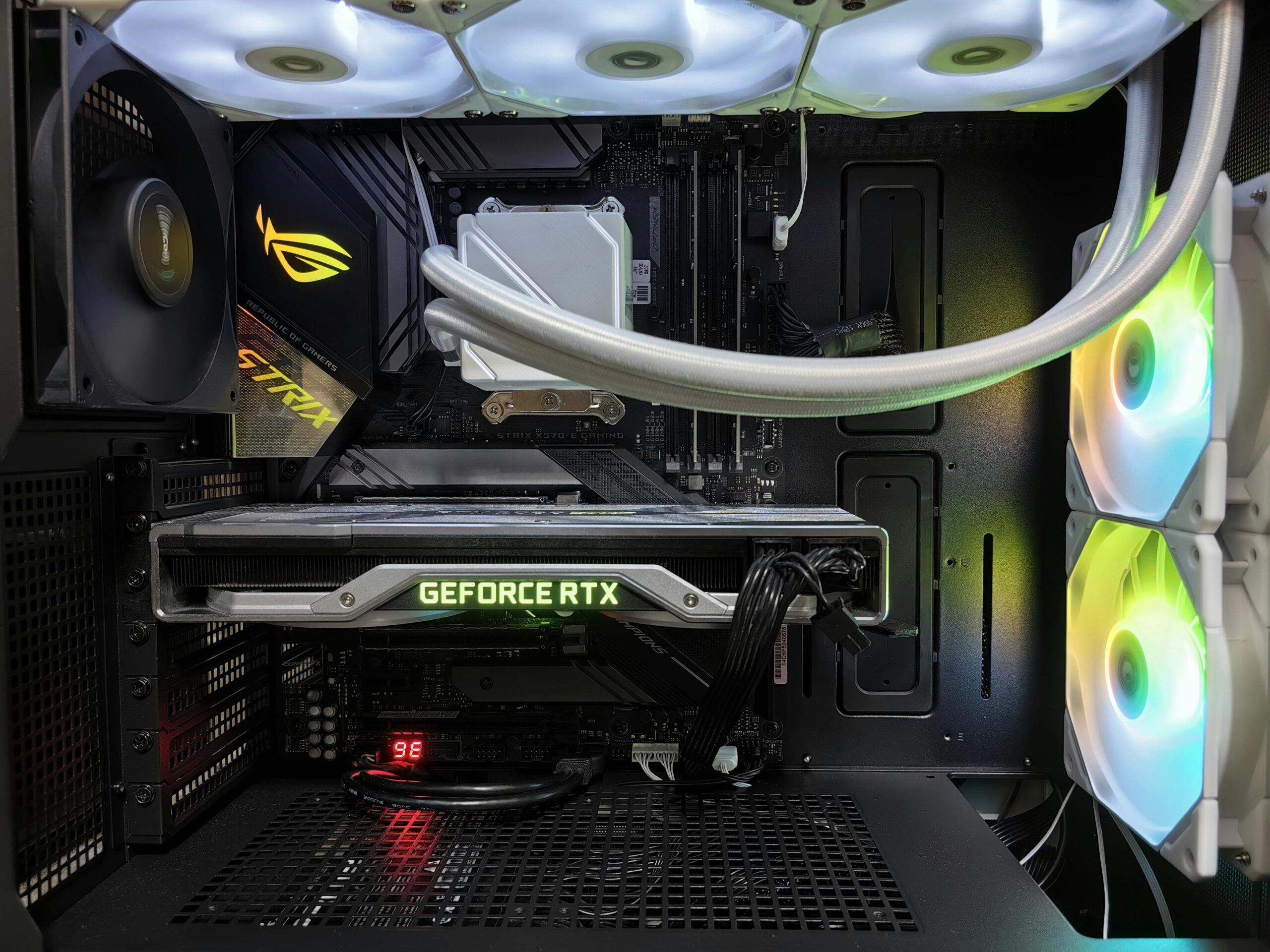 Detailed view of a gaming PC build featuring a GeForce RTX graphics card and RGB lighting in a sleek black case.