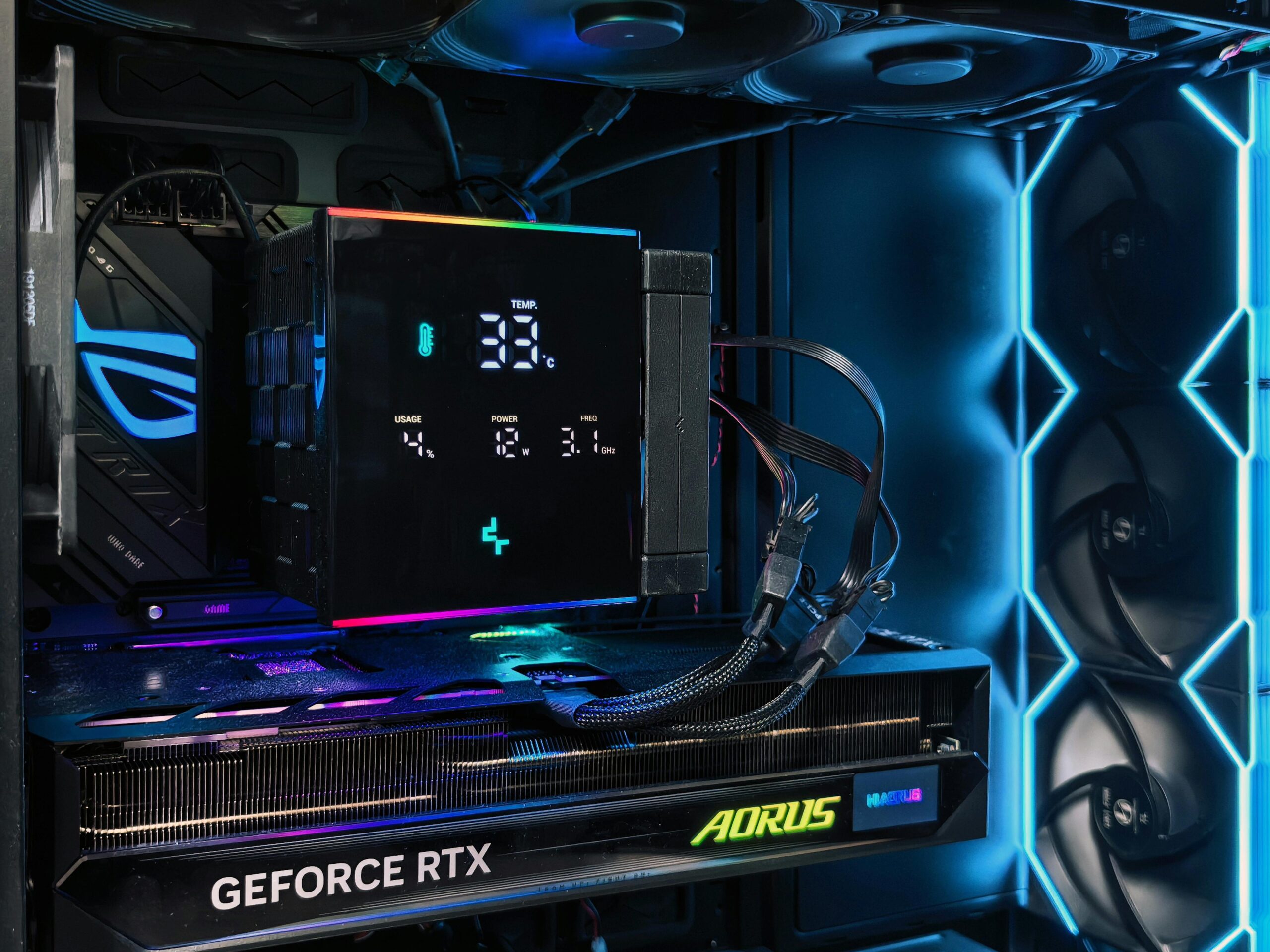 Detailed view of a gaming PC interior featuring an AORUS graphics card and RGB lighting setup.